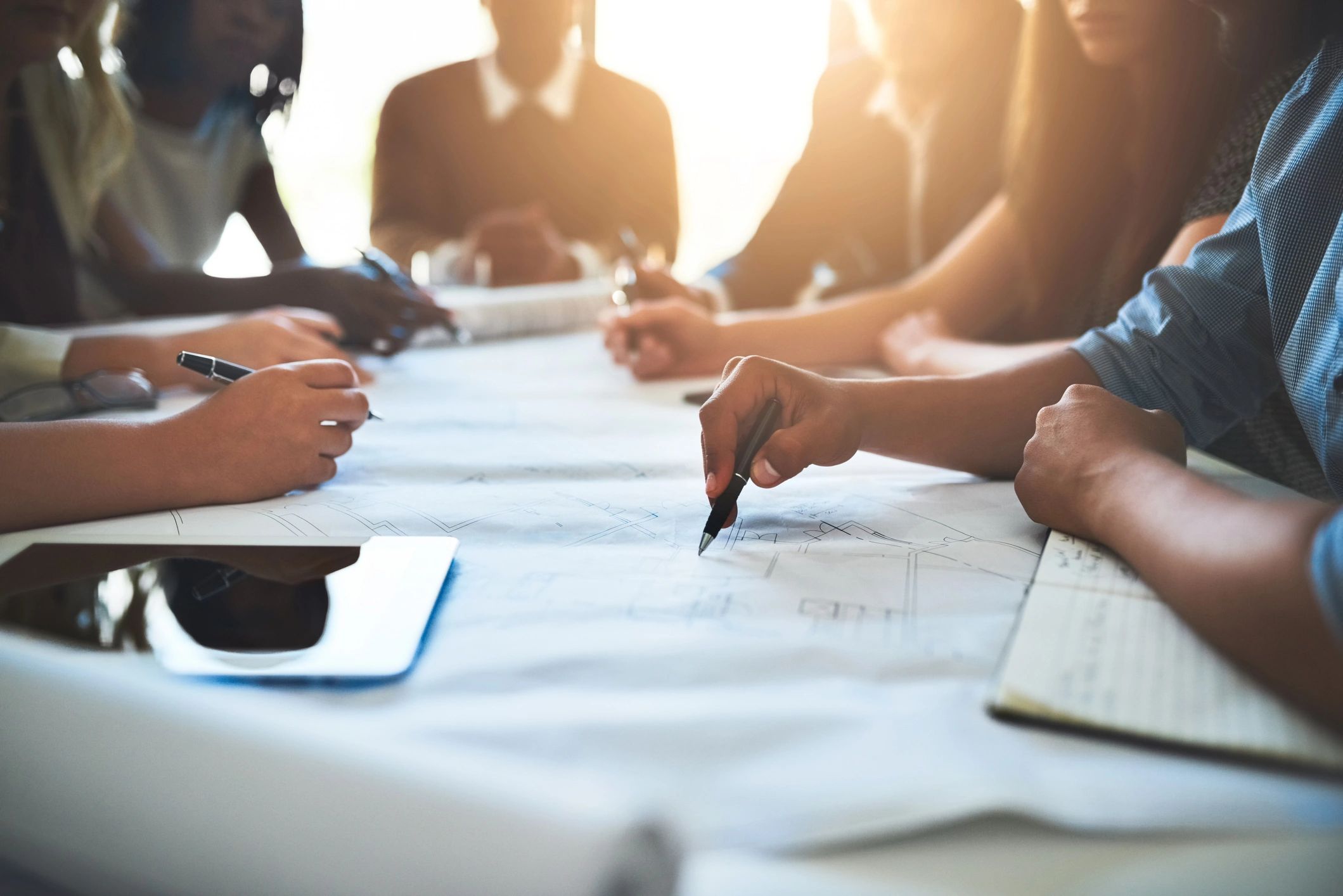 Hands collaborating over architectural plans